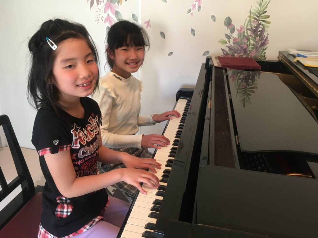 グラウンドピアノと笑顔の女の子2人