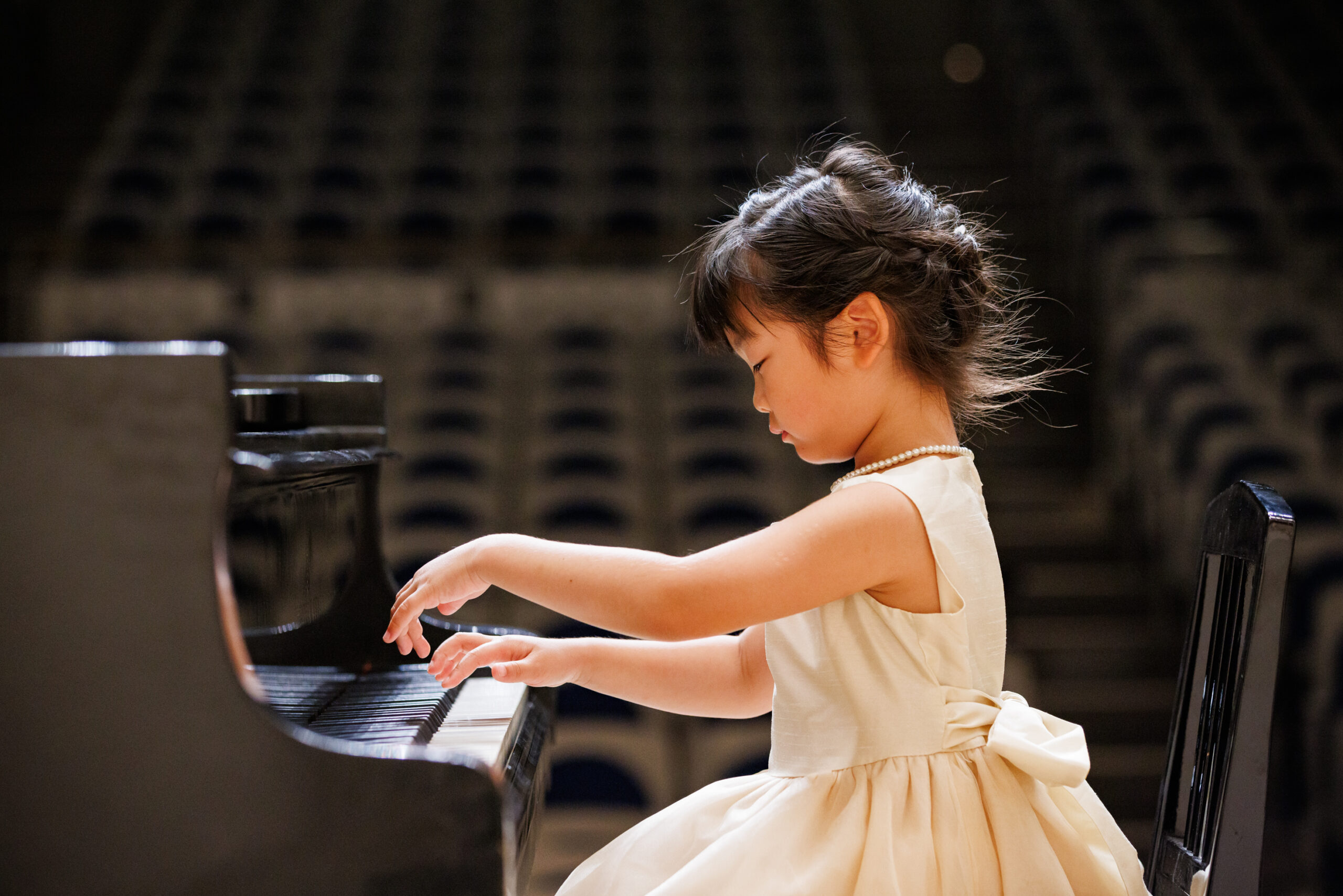 グランドピアノを弾くドレスを着た女の子