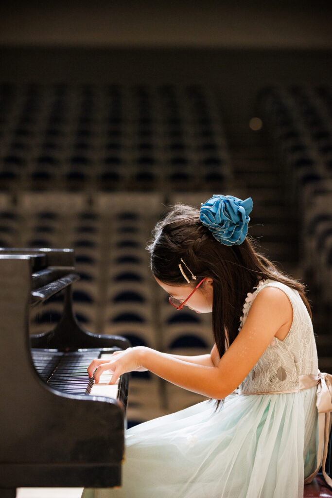 グランドピアノを弾く青いドレスを着た女の子